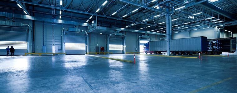 Inside of a warehouse containing big trucks